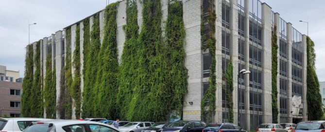Piętrowy parking przy Wallenroda porastający pnączami