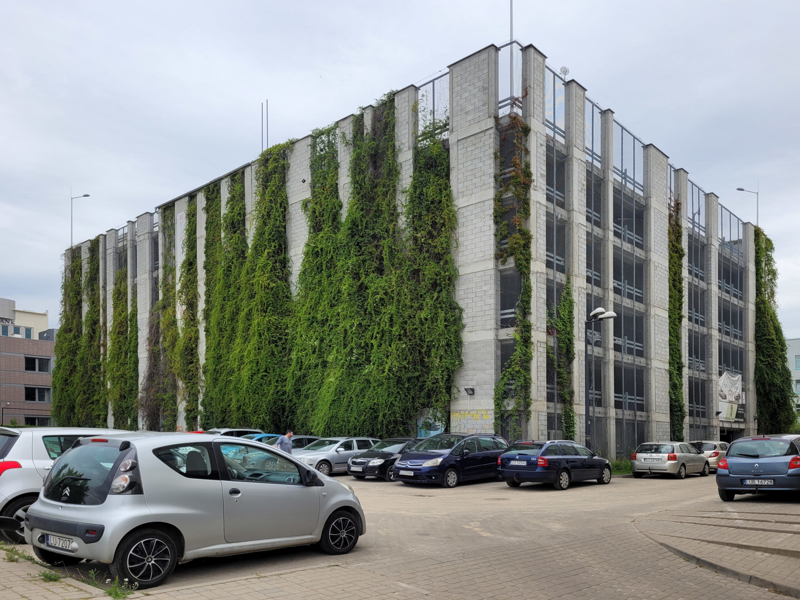 Piętrowy parking przy Wallenroda porastający pnączami