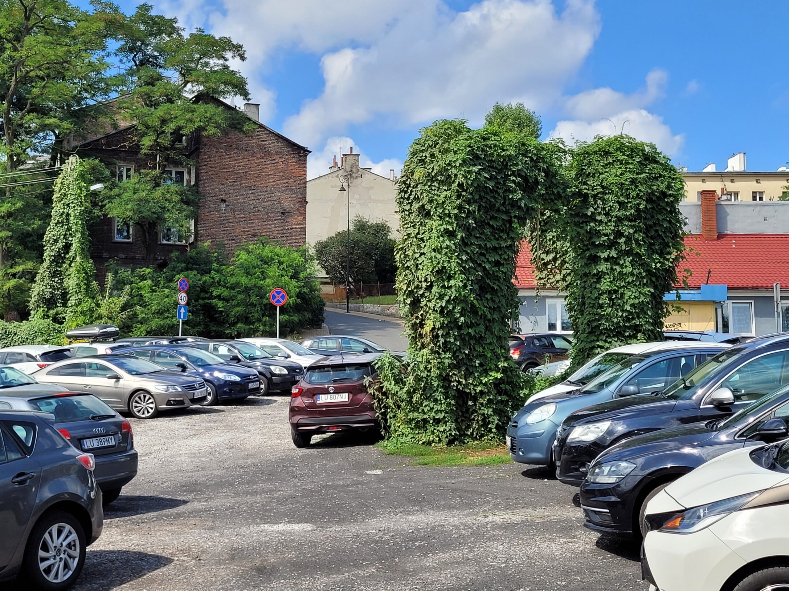 Parking z zarośniętą reklamą na rogu Rusałki i Dolnej Marii Panny