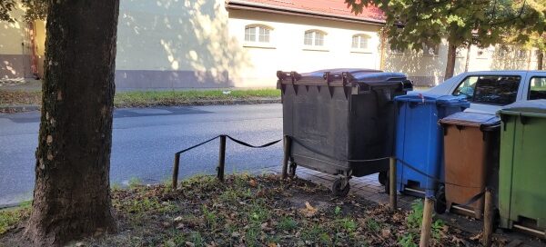 Kosze na śmiecie na trawniku.