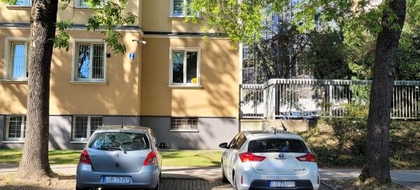 Samochody zaparkowane na miejscach parkingowych.