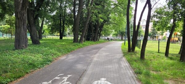 Chodnik i ścieżka rowerowa w osiedlowym parku.