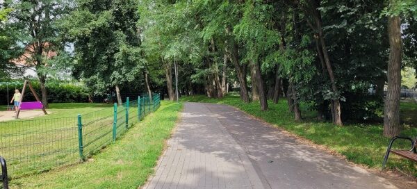 Chodnik i ścieżka rowerowa, obok osiedlowego parku.