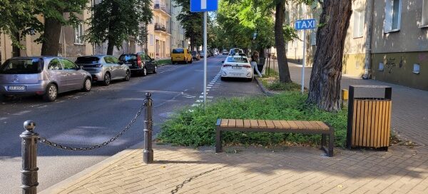 Zielony skwer przy skrzyżowaniu ulic.
