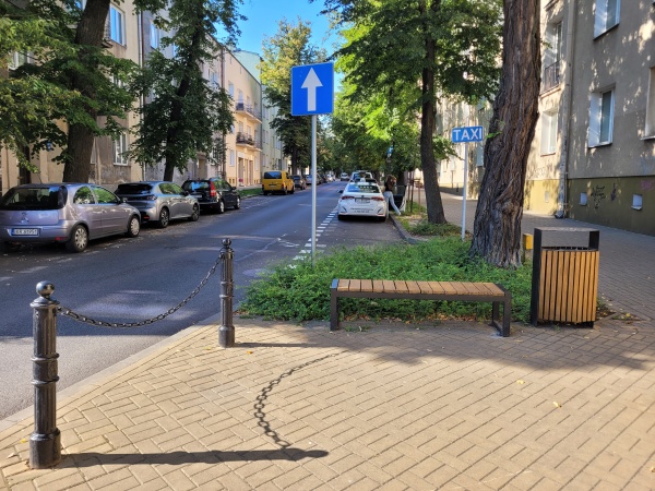 Zielony skwer przy skrzyżowaniu ulic.