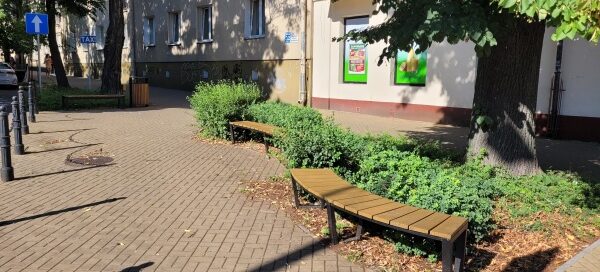 Zielony skwer przy skrzyżowaniu ulic.