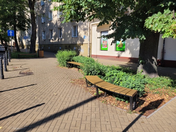 Zielony skwer przy skrzyżowaniu ulic.