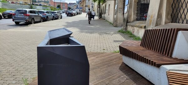 Siedzisko z betonu architektonicznego i drewna, połączone z miejscem na roślinność.