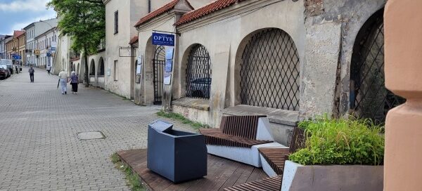 Siedzisko z betonu architektonicznego i drewna, połączone z miejscem na roślinność.