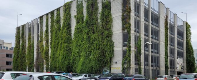 Wielopoziomowy parking, na ścianach którego, zasadzono pnącza.