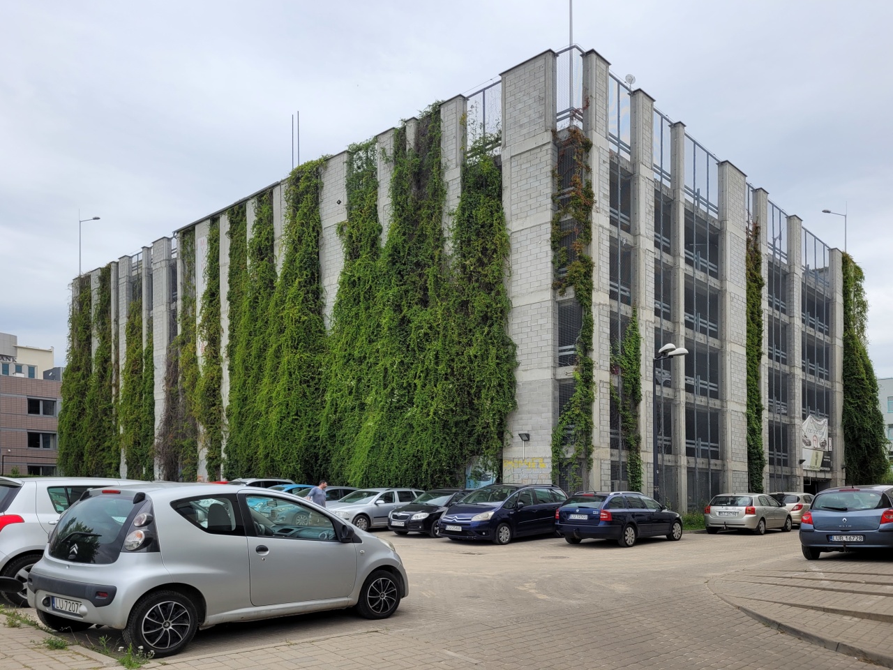 Wielopoziomowy parking, na ścianach którego, zasadzono pnącza.