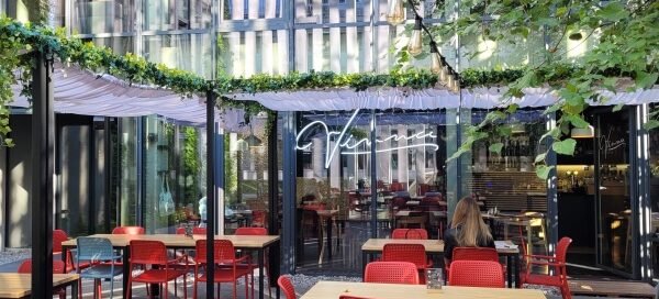 Podwórko restauracji ozdobione pnączami.