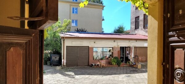 Widok z bramy na podwórko i lokal usługowy.