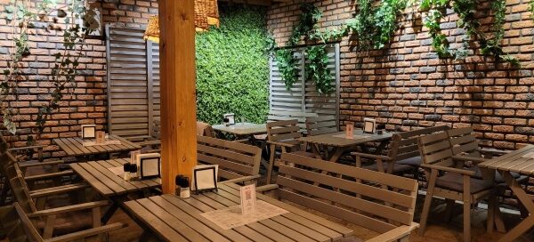 Wnętrze restauracji ozdobionej pnączami.