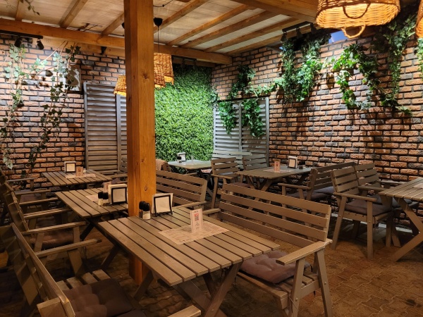 Wnętrze restauracji ozdobionej pnączami.