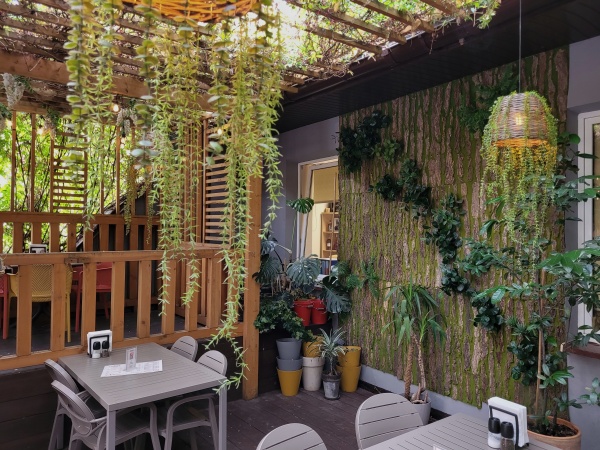 Wnętrze restauracji ozdobionej pnączami.