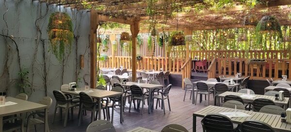 Wnętrze restauracji ozdobionej pnączami.