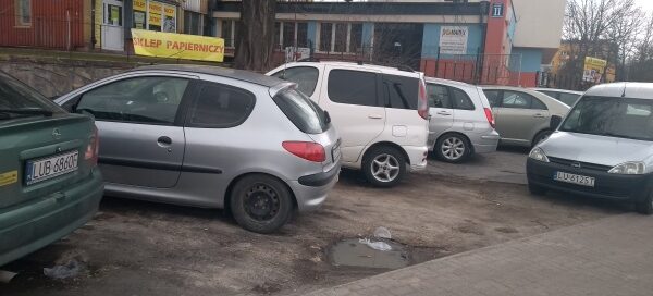 Samochody zaparkowene w miejscu skweru.