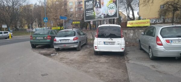 Samochody zaparkowane w miejscu skweru.