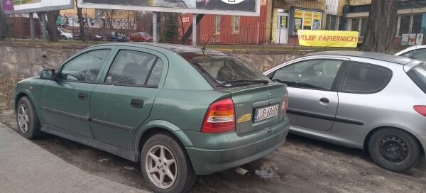 Samochody zaparkowane na miejscu skweru.