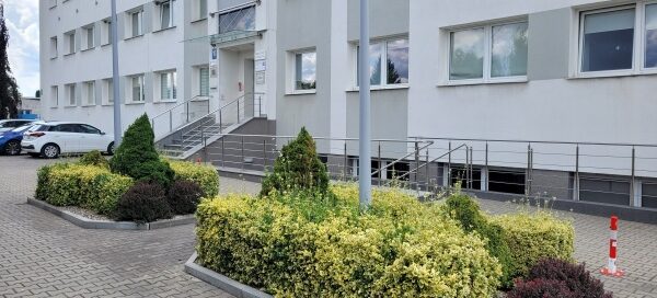 Miejsca przed budynkiem wydzielone na żywopłot.