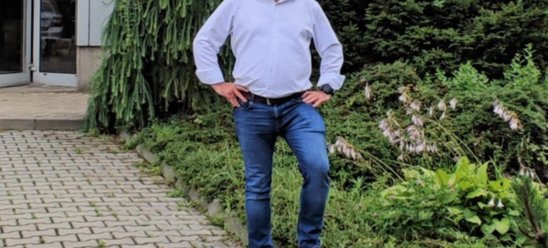 Właściciel firmy stojący obok ogródka.