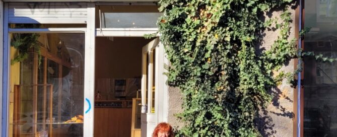 Pnącza ozdabiające fasadę budynku przed lokalem usługowym.