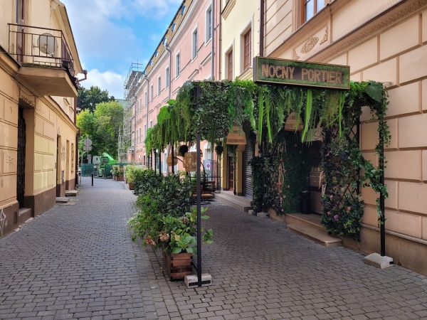Zielona roślinność ozdabiająca zadaszone wejście do jednej z restauracji w centrum miasta.