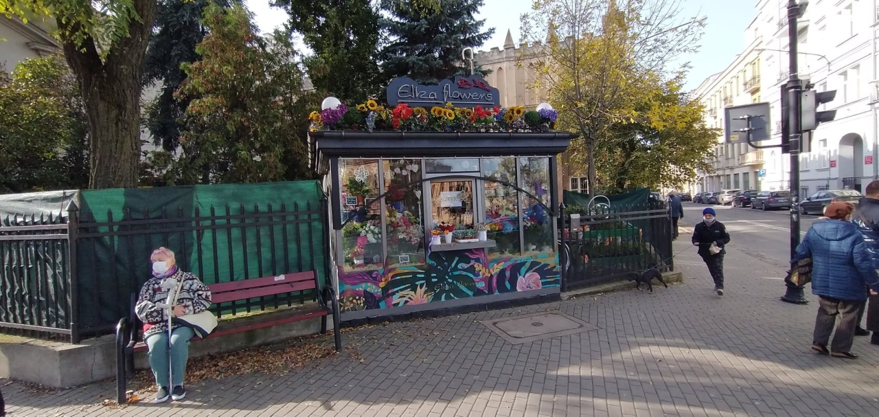 Kiosk z kwiatami w centrum miasta, ozdobiony motywami roślinnymi.